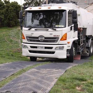 ProtectaMats used by facilities maintenance contractor sweeper truck on grass