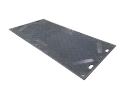A Rectangular, Grey Road Plate With A Textured Surface And Cut-out Handles Around The Edges. The Plate Appears Sturdy, Designed For Construction Or Roadwork Purposes, Featuring Standard Tread For Enhanced Grip. It Is Set Against A Black Background.